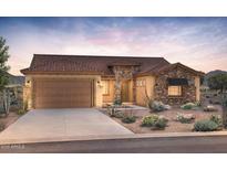 Beautiful single-story home with a two-car garage, desert landscaping, and a mix of stone and stucco exterior at 26650 W Siesta Ln, Buckeye, AZ 85396