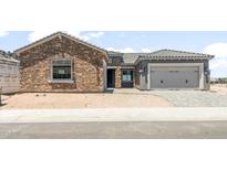 Charming stone and stucco home with a two-car garage and nicely paved driveway at 26650 W Siesta Ln, Buckeye, AZ 85396