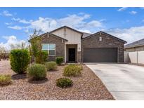 Charming single-story home features a stone facade, well-manicured landscaping, and an attached two-car garage at 36728 N Alderney Ct, San Tan Valley, AZ 85143