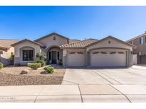 Charming single-story home featuring a three-car garage, desert landscaping, and a tile roof at 7329 W Tether Trl, Peoria, AZ 85383