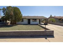 Charming single-story home featuring a well-kept front yard and a carport on a sunny day at 7737 W Medlock Dr, Glendale, AZ 85303