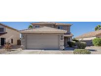 Two-story home featuring a spacious two-car garage, desert landscaping, and neutral color palette at 1010 S 223Rd Ln, Buckeye, AZ 85326