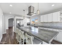 Bright kitchen featuring a large center island, white cabinetry, and stainless steel appliances at 15848 N 32Nd Pl, Phoenix, AZ 85032