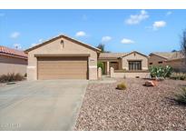 Charming single-story home featuring a desert-landscaped front yard and two-car garage at 17661 N Saddle Ridge Dr, Surprise, AZ 85374