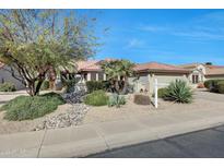 Charming single-story home featuring desert landscaping, a red tile roof and neutral color palette at 18102 N Petrified Forest Dr, Surprise, AZ 85374