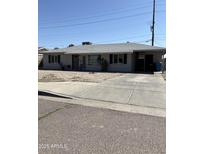 Charming single-story home featuring a long driveway, well-maintained front yard, and covered carport at 3431 W Campbell Ave, Phoenix, AZ 85017