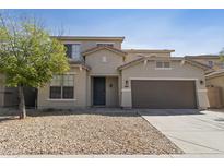 Inviting two-story home with a well-maintained facade, desert landscaping, and an attached two-car garage at 3911 S 100Th Gln, Tolleson, AZ 85353