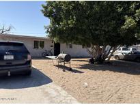 Modest home featuring a sandy front yard with mature shade tree, grill, and driveway parking at 6018 N 32Nd Ave, Phoenix, AZ 85017