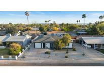 Charming single-story home featuring desert landscaping, palm trees, and a white gravel yard at 901 E Rose Ln, Phoenix, AZ 85014