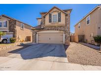 Charming two-story home featuring a stone facade, attached garage, and a well-maintained front yard at 18123 W Lundberg St, Surprise, AZ 85388