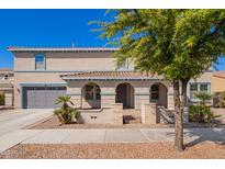 Beautiful two-story home featuring manicured landscaping, a gray garage door, and inviting covered porch at 21256 E Waverly Dr, Queen Creek, AZ 85142