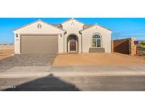 Charming single-story home featuring a neutral color palette, a two-car garage, and a welcoming front entrance at 21287 N 272Nd Ln, Buckeye, AZ 85396