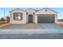 Charming single-story home with a two-car garage and desert landscaping at 21288 N 272Nd Ln, Buckeye, AZ 85396