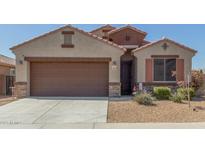 Charming single-story home with a two car garage, desert landscaping, and a tile roof at 2424 S 235Th Dr, Buckeye, AZ 85326