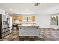 Well-appointed kitchen featuring stainless steel appliances, granite countertops, and a center island at 3144 W Maya Way, Phoenix, AZ 85083