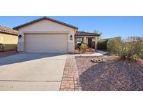Charming single-story home featuring a desert landscape, brick walkway and two car garage at 325 W Angus Rd, San Tan Valley, AZ 85143