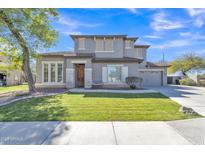 Charming two-story home featuring a well-manicured lawn and a neutral-toned exterior with stone accents at 3419 E Rosa Ln, Gilbert, AZ 85297