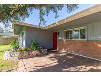 Charming entryway featuring a red front door, brick accents, and a delightful flower bed at 5522 N 4Th Ave, Phoenix, AZ 85013