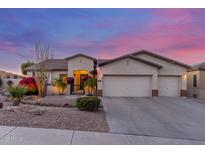Charming single-story home featuring a 3-car garage and desert landscaping at dusk at 6022 W Fetlock Trl, Phoenix, AZ 85083