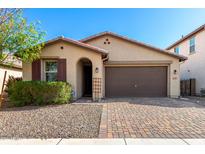 Inviting single-story home with a brick driveway, desert landscaping, and cozy front entrance, creating a welcoming curb appeal at 8515 W Peppertree Ln, Glendale, AZ 85305