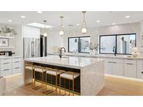 Bright kitchen with large island, marble counters, pendant lighting and stainless steel appliances at 10905 E San Salvador Dr, Scottsdale, AZ 85259