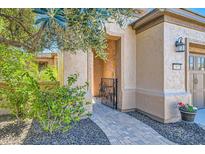 Inviting entryway with stone pathway, wrought iron gate, and a charming courtyard at 13055 W Cliffrose Rd, Peoria, AZ 85383