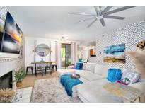 Bright living room featuring plush seating, ceiling fan, dining table and eye-catching accent wall at 15252 N 100Th St # 2141, Scottsdale, AZ 85260