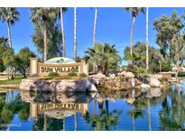 Sun Village entry sign surrounded by lush landscaping, rock features and beautiful water features at 17254 N White Cloud Cir, Surprise, AZ 85374