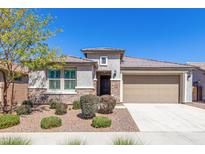 Charming single-story home featuring a stone facade, desert landscaping, and a two-car garage at 22854 E Pummelos Rd, Queen Creek, AZ 85142