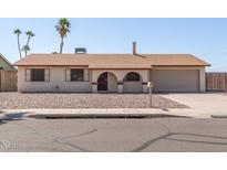 Charming single-story home with a two-car garage, arched entry, and desert landscaping at 4233 W Paradise Dr, Phoenix, AZ 85029