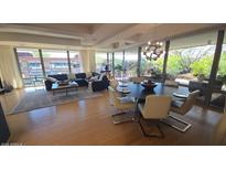 Bright living and dining area with wood floors, modern lighting, and large windows overlooking the community gardens at 7147 E Rancho Vista Dr # 7004, Scottsdale, AZ 85251