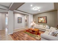 Inviting living room featuring neutral tones, wood floors, and comfortable sofas, perfect for relaxing at 9336 W Louise Dr, Peoria, AZ 85383