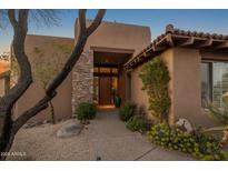 Inviting front entrance with stone accents, mature landscaping and a walkway to the front door at 9904 E Lookout Mountain Dr, Scottsdale, AZ 85262