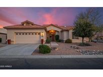 Charming single-story home featuring a tile roof, desert landscaping, and a two-car garage at 15145 W Catalina Dr, Goodyear, AZ 85395