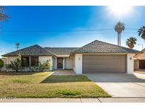 Inviting single-story home with a gray roof, green lawn, and an attached two-car garage at 1531 W Naranja Ave, Mesa, AZ 85202