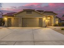 Spacious home featuring a three-car garage with a large driveway and a tile roof, set against a beautiful dusk sky at 1710 W Winchester Way, Chandler, AZ 85286