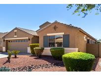 Close up of the home's front landscaping with trimmed bushes and a two car garage at 605 E Nancy Ave, San Tan Valley, AZ 85140