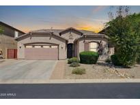 Inviting single-story home featuring a two-car garage and desert landscaping, with a warm color scheme at 7576 W Fetlock Trl, Peoria, AZ 85383