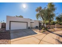 Charming single-story home featuring a two-car garage and xeriscaped front yard with mature tree at 7721 E Valley Vista Ln, Scottsdale, AZ 85250