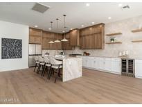 Modern kitchen island bar with pendant lights, updated stainless appliances and sleek countertops at 11267 E Beck Ln, Scottsdale, AZ 85255