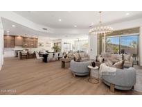 Bright open-concept living area featuring a chandelier, modern furnishings, and seamless indoor-outdoor flow to the patio at 11267 E Beck Ln, Scottsdale, AZ 85255