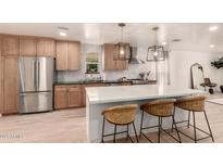 Bright kitchen boasts stainless steel appliances, pendant lighting, and a large center island with barstool seating at 1838 E Crocus Dr, Phoenix, AZ 85022