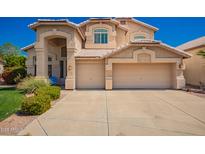 Beige two-story home with a two-car garage and a well-maintained front yard at 2741 N 137Th Ave, Goodyear, AZ 85395