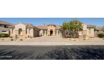Stunning single-story home with a tile roof, well-manicured landscaping, and a circular paver driveway at 3822 E Tracker Trl, Phoenix, AZ 85050