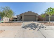 Charming single-story home with a two-car garage, desert landscaping, and neutral exterior paint at 40467 W Jenna Ln, Maricopa, AZ 85138