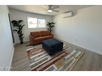Bright living area features modern rug, comfortable sofa, ottoman, and window with natural light at 5024 W Osborn Rd, Phoenix, AZ 85031