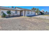 Single-Gathering home with tan siding, a brick pillar, and an attached garage on a sunny day at 6025 W Marconi Ave, Glendale, AZ 85306