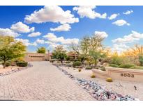 Beautiful desert landscaping and paver driveway leading up to this charming home, with a beautiful blue sky overhead at 8003 E Sands Dr, Scottsdale, AZ 85255