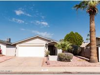 Charming single-story home featuring a well-maintained front yard with mature trees and a two-car garage at 8666 E Fillmore St, Scottsdale, AZ 85257