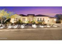 Charming single-story home featuring a stone facade, tile roof, and beautifully landscaped front yard with desert accents at 1708 W Gambit Trl, Phoenix, AZ 85085